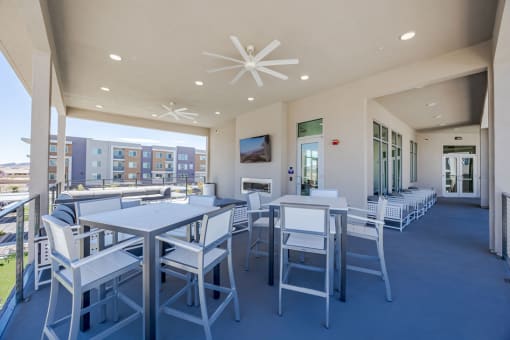 a patio with tables and chairs and a fireplace at Element 12 Apartments, Henderson NV