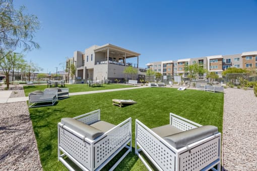 a park with lawn furniture and a building in the background at Element 12 Apartments, Henderson NV