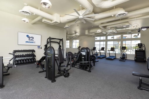 the large fitness room with cardio equipment and windoes at Element 12 Apartments, Henderson NV