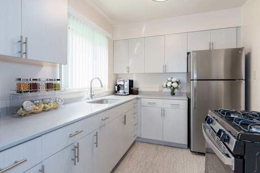 A modern kitchen with white cabinets and stainless steel appliances at Hillsdale Garden Apartments, CA, 94403