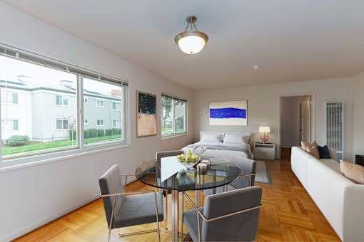 a bedroom with a bed and a table with chairs  at Hillsdale Garden Apartments, San Mateo