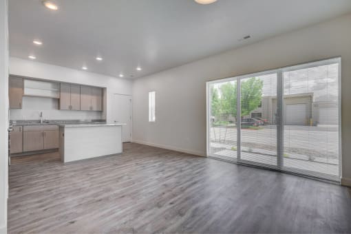 the living room and kitchen of a new home with a large sliding glass door