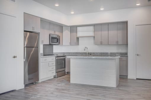 a kitchen with an island and stainless steel refrigerator