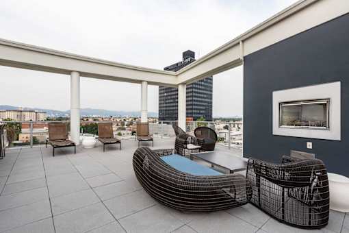 A modern outdoor patio with a hot tub and chairs.