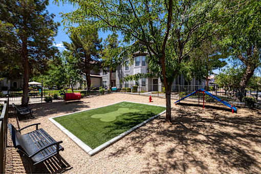A playground with a slide, swings, and a bench.
