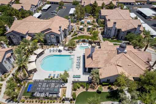 A large swimming pool surrounded by a tiled roofed building.