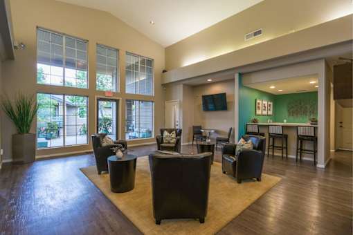 A living room with a large couch and a television on the wall.
