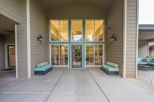 A building with a glass door and two benches in front.
