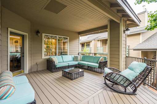 A wooden deck with a sofa and chairs.
