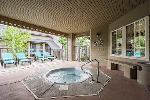 A hot tub is in the middle of a covered patio.