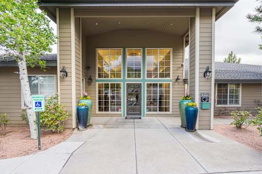 A building with a large glass door and a sign that says "WHEELCHAIR" in front of it.
