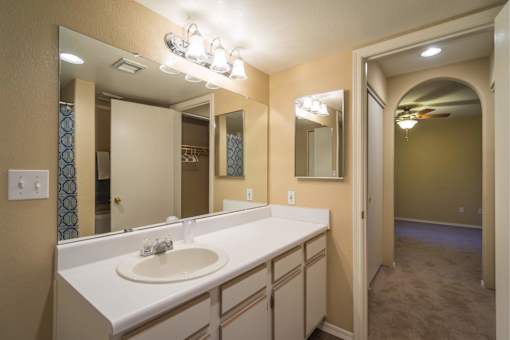 A bathroom with a white sink and a mirror above it.