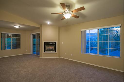 A living room with a fireplace and a ceiling fan.