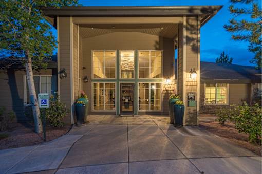 The image shows a building entrance with a glass door and a signboard.