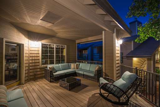 A wooden deck with a sofa and chairs.