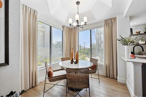 a dining room with large windows and a chandelier