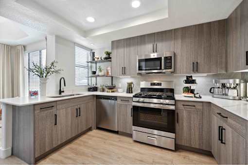 a kitchen with gray cabinets and white countertops