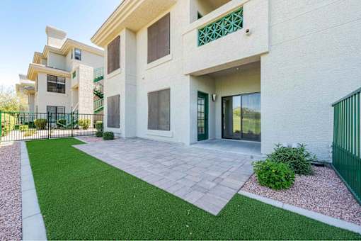 a patio in front of a building with green grass