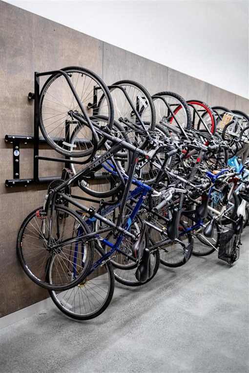 A wall-mounted bike rack is full of bicycles.