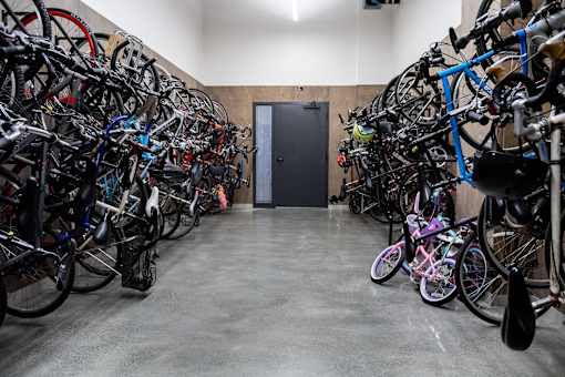A bike storage room with many bikes on racks.