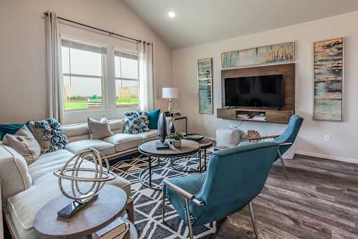 A living room with a white couch, a blue chair, and a wooden coffee table.