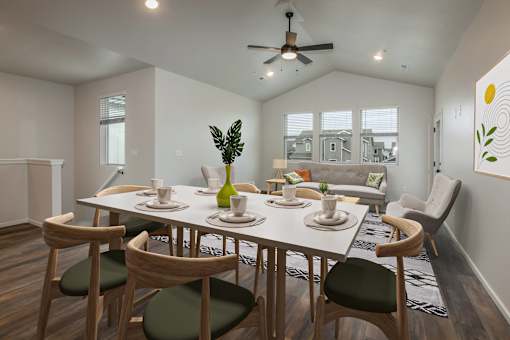 A dining room with a white table and chairs.