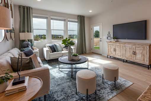A living room with a white couch, a glass table, and a television on a wooden cabinet.