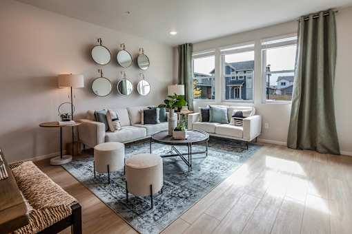 A living room with a white couch, a coffee table, and a rug.