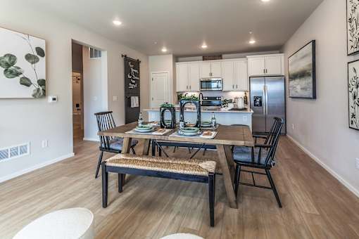 A modern kitchen with a dining table and chairs.