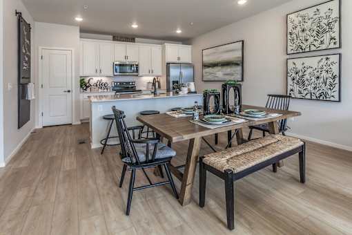 A kitchen with a dining table and chairs.