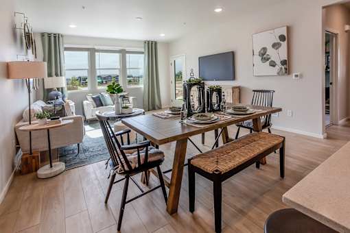 A dining room with a wooden table and chairs.