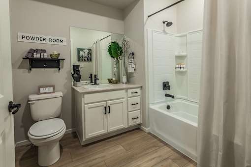 A white powder room with a toilet, sink, and shelves.