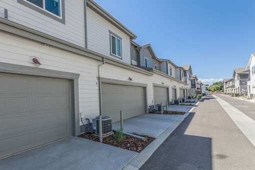 A row of houses with garages and driveways.