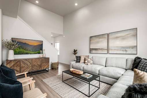 A living room with a grey sofa, a black chair, and a coffee table.