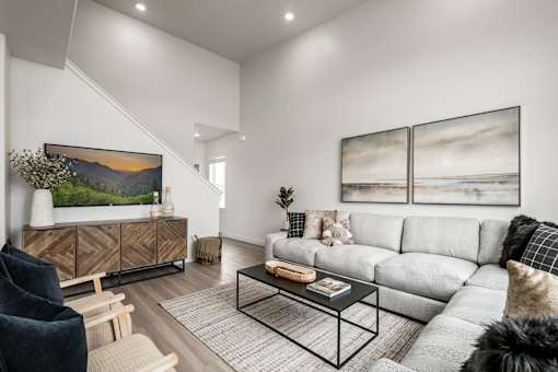A living room with a grey sofa, a black chair, and a coffee table.
