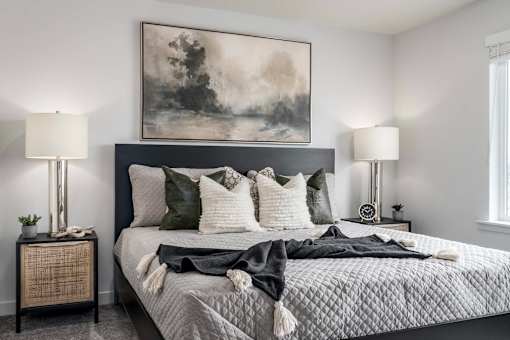 A bedroom with a large bed and a painting above it.