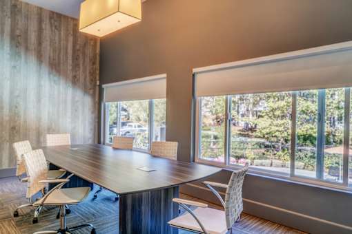A conference room with a long table and chairs.