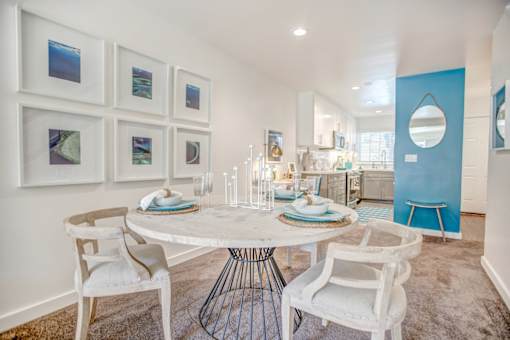 A dining room with a white table and chairs.