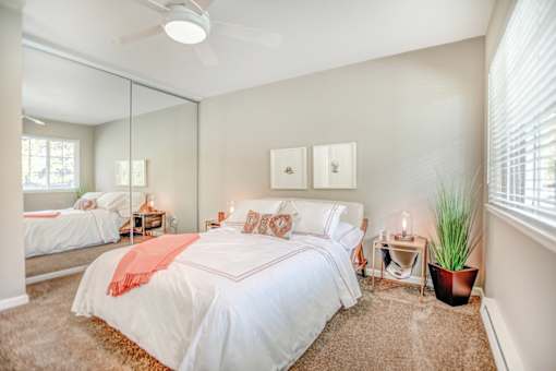 A bedroom with a large bed and a ceiling fan.