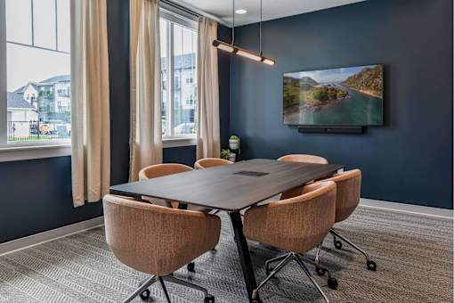 A conference room with a large table and chairs.