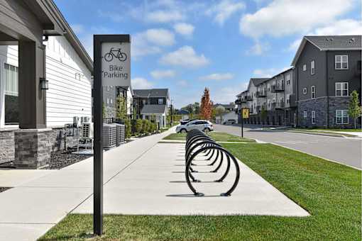 A row of bike racks are lined up on a sidewalk in front of a building.