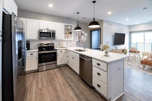 A modern kitchen with white cabinets and stainless steel appliances.
