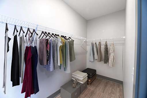 A row of clothes hanging on a rack in a room.