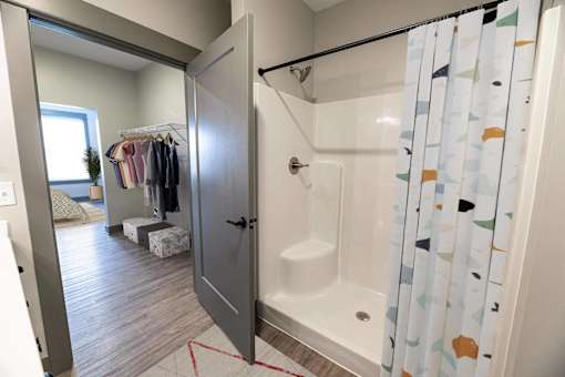 A bathroom with a shower and a wardrobe.