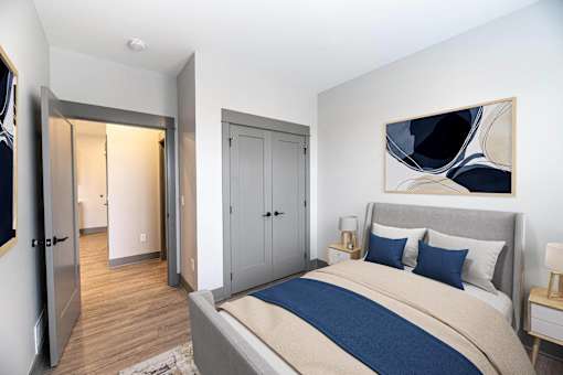 A bedroom with a bed, a nightstand, and a painting on the wall.