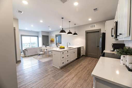 A modern kitchen with a dining area and a living room.