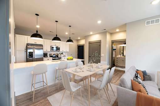 A modern kitchen with a dining table and chairs.