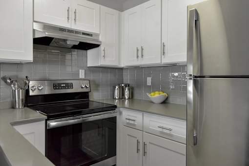 White cabinet kitchen with stove and refrigerator at The Villas at Northstar apartments for rent in Ann Arbor, MI