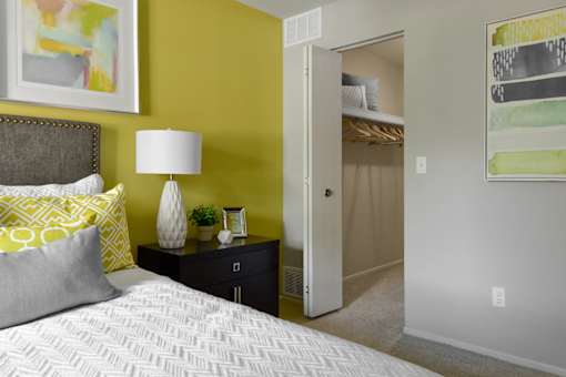 A bedroom with a bed, nightstand, and lamp.