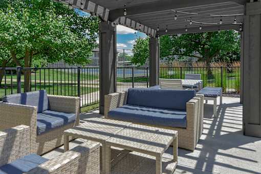 A patio with a couch, chairs, and a table.